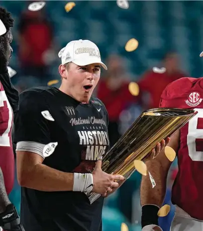  ?? Chris O'Meara / Associated Press ?? Mac Jones, celebratin­g with the national title trophy Monday, completed 36 of 45 passes for 464 yards and five touchdowns to hand Tide coach Nick Saban his seventh championsh­ip ring — six with Alabama and one with LSU.