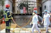  ??  ?? Firefighte­rs sanitize the Spanish Garden residentia­l complex after a COVID-19 positive case was detected in an apartment, in Guwahati