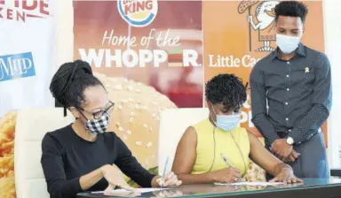  ??  ?? (From left) Arlene Martin, acting general manager, Profession­al Football Jamaica Limited, and Sabrena Mcdonald Radcliffe, head of sales & marketing at Restaurant Associates Limited, sign the agreement as Oshane Thoms, brand manager, Popeyes and Little Caesars Pizza, looks on.