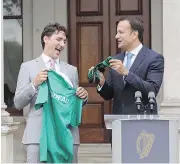  ?? PAUL FAITH/AFP/GETTY IMAGES ?? Prime Minister Justin Trudeau is given a rugby jersey and pair of socks Tuesday in Dublin by Ireland’s Prime Minister Leo Varadkar.
