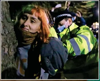  ??  ?? Seized: A woman is held by an officer then has her hands cuffed behind her back in the same manner as Patsy Stevenson, main picture