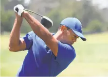  ?? Ross Kinnaird / Getty Images ?? Tiger Woods warms up on the driving range during a practice round at Pebble Beach, where he won the U.S. Open in 2000.