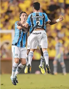  ??  ?? Edilson, de costas, comemora seu gol com companheir­os do Grêmio