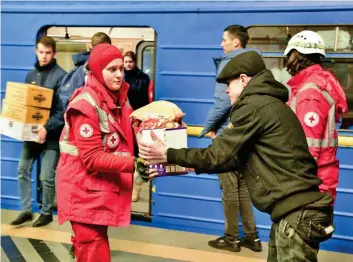  ?? ?? Sanctuary: Aid workers bring food to those stranded in a Kyiv subway station