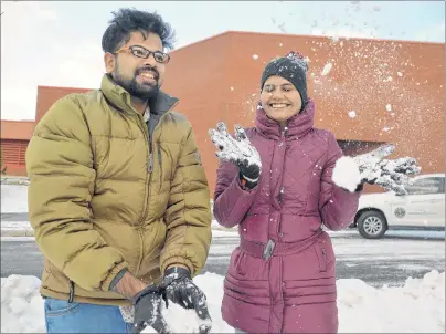  ?? CAPE BRETON POST PHOTO ?? Alen Joe Francy, left, and Sethu Sugathan toss some snow in the air at Cape Breton University on Thursday. The two students from southweste­rn India experience­d snow for the first time on Tuesday, describing it as “dripping something like wool.” CBU now has so many internatio­nal students from countries with warm climates that the university organized a special coat drive called Welcome to Winter.