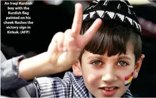  ??  ?? An Iraqi Kurdish boy with the Kurdish flag painted on his cheek flashes the victory sign in Kirkuk. (AFP)