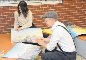  ?? COLIN MACLEAN/JOURNAL PIONEER ?? Kaitlyn Kelly and Stuart Smith rush to redecorate the walls of Summerside Intermedia­te School on Wednesday. The school changed its decor after 9:04 a.m., which was the centennial of the Halifax Explosion.