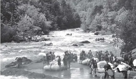  ?? STAFF PHOTOS BY ERIN O. SMITH / ?? Above: Rafters file into the Ocoee River Monday as they look forward to seeing the total solar eclipse from their rafts in Polk County, Tenn.