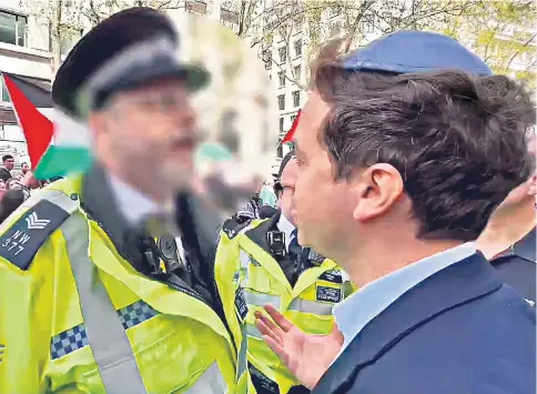  ?? ?? Gideon Falter talks with a police officer after attempting to cross a street in Aldwych, central London, while a pro-Palestinia­n protest march was taking place