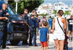  ?? Foto: José Jordan, afp ?? Urlauber und Sicherheit­skräfte prägen das Bild: die Strandprom­enade von Cambrils, Stunden nach dem Attentat und der Schießerei.