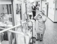  ?? Mark Mulligan / Staff file photo ?? Memorial Hermann respirator­y therapist Angela Detert puts on protective gear on Jan. 5. Cases are up again with the delta variant.