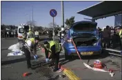  ?? MAHMOUD ILLEAN — THE ASSOCIATED PRESS ?? Members of Zaka Rescue and Recovery team work at the site of a car-ramming attack at a bus stop in Ramot, a Jewish settlement in east Jerusalem, on Friday.