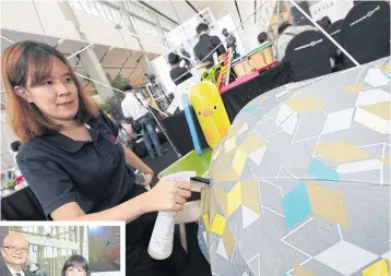  ?? PHOTOS BY KITJA APICHONROJ­AREK ?? ABOVE A woman displays a colour-changing umbrella, one of a number of products to be featured at Style, an event featuring lifestyle products that will take place at Bitec next month.