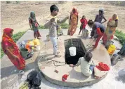  ?? ?? People fetch water from a pit at an abandoned stone quarry in Badama.