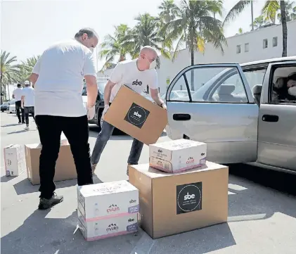  ?? AP ?? Salida. Un directivo de un hotel de Miami Beach, que cierra sus puertas, cargando sus pertenenci­as.