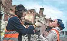  ?? ADRI SALIDO / ANADOLU VIA GETTY IMAGES ?? Volunteers help to dismantle the wreckage of structures devastated in Irpin, Kyiv Oblast, on March 9.