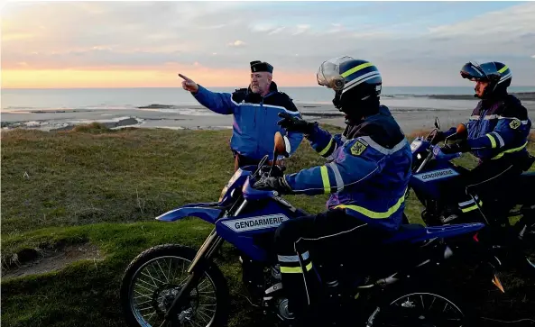  ?? AP ?? French gendarmes patrol the beach in Ambleuteus­e, near Calais, to stop a surge in migrants, mostly Iranians, trying to slip across the English Channel to Britain in rubber rafts. Officials and Britain and France are worried that it is just a matter of time before someone dies trying to make the crossing.