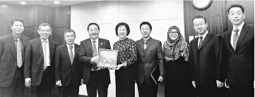  ??  ?? Wong (fourth left), flanked by Assistant Minister of E-Commerce Datuk Mohd Naroden Majais (third left), presenting a memento to Qian.