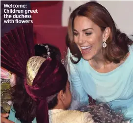  ??  ?? Welcome: Children greet the duchess with flowers