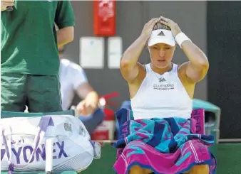  ?? THE ASSOCIATED PRESS ?? Germany’s Angelique Kerber takes a break as she plays Spain’s Garbine Muguruza during their match on day seven at the Wimbledon Tennis Championsh­ips in London Monday. Top-ranked Kerber lost 4-6, 6-4, 6-4.