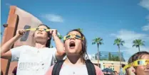  ?? NICK OZA/THE REPUBLIC ?? TOP: Lauren Grant views the solar eclipse at the Arizona Science Center. MIDDLE: Central Arizona saw a two-thirds eclipse. BOTTOM: Visitors watch the eclipse on ASU’s Tempe campus.