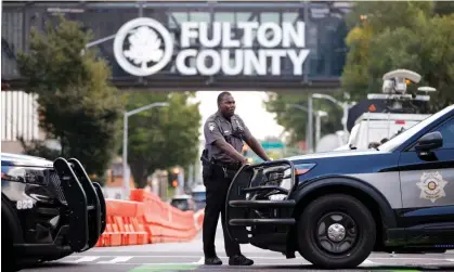  ?? Photograph: Alex Slitz/AP ?? A sheriff's deputy stands guard near the Fulton county courthouse in Atlanta this week. Authoritie­s are investigat­ing threats against grand jury members.