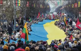  ?? MINDAUGAS KULBIS/AP ?? People carry a giant Ukrainian flag to protest the Russian invasion of Ukraine during a celebratio­n of Lithuania’s independen­ce in Vilnius, Lithuania, on Saturday, the 33rd anniversar­y of its independen­ce from the Soviet Union.