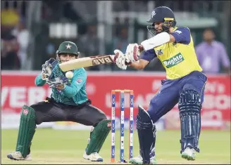  ?? (AFP) ?? World XI batsman Hashim Amla (right), plays a shot as Pakistani captain and wicketkeep­er Sarfraz Ahmed looks on during the second Twenty20 internatio­nal cricket match between the World XI and Pakistan at The Gaddafi Cricket Stadium in Lahore on Sept 13.