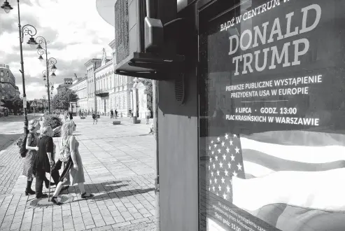  ?? Associated Press ?? In this photo taken Saturday, women walk by a poster advertisin­g President Donald Trump’s speech, which reads, “Donald Trump. First Public Appearance in Europe,” in Warsaw, Poland. President Donald Trump has broken with tradition in deciding to visit...