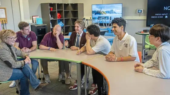  ?? Pittsburgh Post-Gazette ?? Greensburg Central Catholic Junior-Senior High School guidance counselor Carla Burke, left, discusses Thanksgivi­ng and Christmas experience­s with some of the school’s internatio­nal students. Seated, from left, are Gianmarco Ariola, 16, from Italy; Egor Busygin, 16, from Russia; Yahor Ramanau, 16, from Belarus; Kamil Zainullin, 16, from Russia; Sanad Eljali, 17, from Libya; and Hunuk Cho, 19, from South Korea.