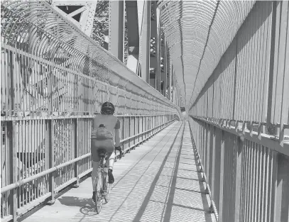  ??  ?? A cyclist rides on the Jacques Cartier Bridge in Montreal. Windsor could take a page out of that city’s playbook and promote cycling events that provide a financial boost to the economy and maybe prompt some to return, says letter writer Alan Henderson.