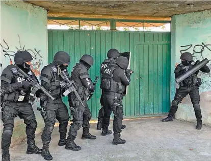  ?? ESPECIAL ?? Policías a punto de ingresar a la casa donde estaba el médico plagiado.