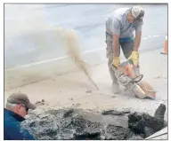  ??  ?? While Rocky Mills (left) keeps an eye on a water leak while David Flynt uses a diamond-tipped concrete saw to cut a piece of the road away June 10 near Grand Saving Bank in Decatur. The rooster tail of dust behind Flynt is the result of the saw kicking fine dust along the underside of the cut and blowing it into the air. (NWA Democrat-Gazette/Mike Eckels)