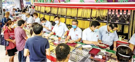  ?? — AFP photo ?? People wearing face masks amid fears of the spread of Covid-19 coronaviru­s sell their jewelries in a gold shop in Bangkok’s Chinatown.