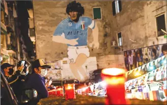  ?? Associated Press photo ?? People light candles to honour Diego Maradona, in Naples, Italy, Wednesday. Diego Maradona has died. The Argentine soccer great was among the best players ever and who led his country to the 1986 World Cup title before later struggling with cocaine use and obesity. He was 60.