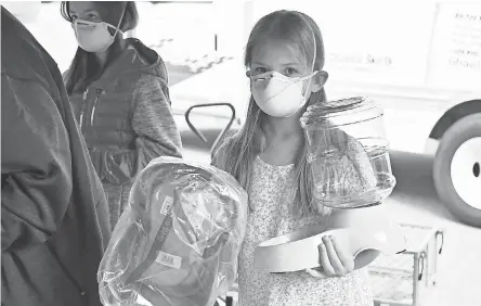  ?? CALLEY CEDERLOF ?? Clarisa Copsey, 8, holds supplies for her dog at the pet supply and food pantry in Chico, Calif.