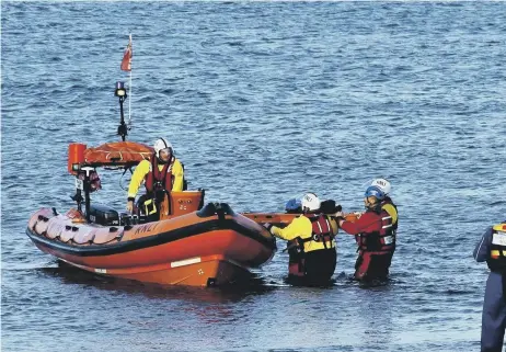  ??  ?? CROs help a lifeboat crew with a casualty.