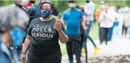  ?? JESSICA MCGOWAN GETTY IMAGES ?? Tamara Ross waits to vote in Atlanta, Ga. this week. Some voters waited in line all day and many experts say the lines are a sign of voter suppressio­n.