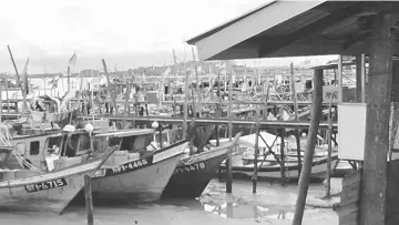  ??  ?? Fishing boats berthed at a jetty in Goebilt area in Kuching.