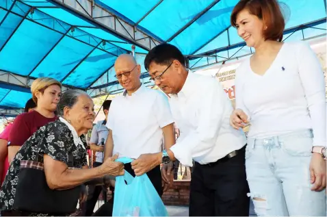  ?? Chris Navarro ?? ‘MALASAKIT.’ Mayor Edwin Santiago, Vice-Mayor Jimmy Lazatin and Councilor Angie Hizon distribute grocery packs to families of veterans as manifestat­ion of the city government’s ‘malasakit’to Fernandino­s who fought for democracy.—