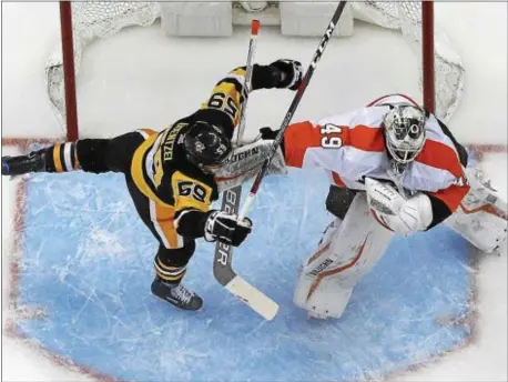  ?? THE ASSOCIATED PRESS FILE ?? Alex Lyon is still a relative newcomer, but as he showed Pittsburgh’s Jake Guentzel in this game last March, he can play an old-Flyers-school brand of goaltendin­g.