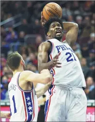  ?? BILL STREICHER / USA TODAY SPORTS ?? Philadelph­ia 76ers center Joel Embiid hauls down a rebound against the Toronto Raptors in Philadelph­ia on Wednesday. The 76ers won 94-89.