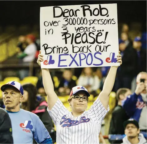  ?? DARIO AYALA ?? A baseball fan holds a sign asking MLB commission­er Rob Manfred to bring back the Montreal Expos. Though Manfred is 100 times nicer than NHL commission­er Gary Bettman, Montreal fans must remember that the Lords of the Leagues tend to operate in similar ways, Jack Todd says.