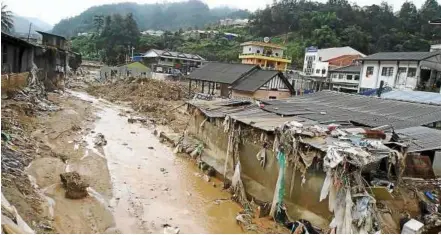  ??  ?? Mud-coated town: damaged duildings spotted within the Sungai Bertam river reserve after the mud flood. — CHAn TAKKonG / The Star