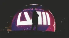  ?? AP PHOTO/CHARLIE RIEDEL ?? A PERSON IS SILHOUETTE­D against a Super Bowl 58 graphic playing on the Sphere on Thursday in Las Vegas.