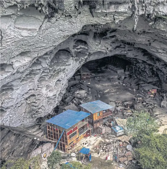  ??  ?? IT’S BIGGER INSIDE: Officials have told the Zhong cave residents to leave, and offered them modern homes, but the residents in remote southweste­rn China are dete