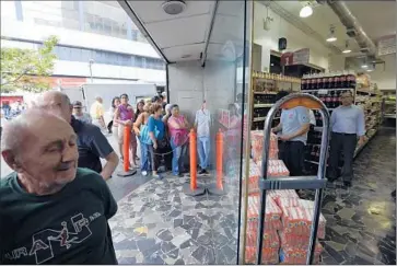  ?? Juan Barreto
AFP/Getty Images ?? VENEZUELAN­S line up outside a supermarke­t to buy soap powder in Caracas in February. President Nicolas Maduro has declared “economic war” on black marketeers, but things have not improved for many shoppers.