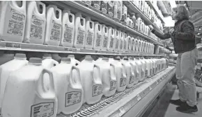  ?? ASSOCIATED PRESS ?? A shopper looks over the milk aisle at the Hunger Mountain Co-op in Montpelier, Vt., in 2009