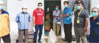  ??  ?? Dr Abdul Rahman (third right) and other local dignitarie­s at the handing-over of food items to villagers at Kampung Pahlawan.