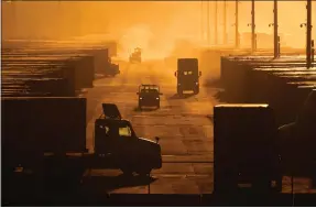  ?? CHARLIE RIEDEL - THE ASSOCIATED PRESS ?? Workers drive among shipping containers and trailers at a BNSF intermodal terminal Jan. 3 in Edgerton, Kan. On Wednesday, the government issued the second of three estimates of GDP growth during the October to December quarter.